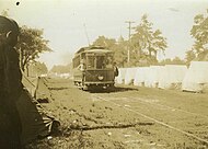 A North Hill line streetcar travels south down Palafox Street past State militia encampments.