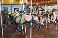 Note the slots in the floor that allow the horses to tilt while the carousel is in motion, an unusual feature.