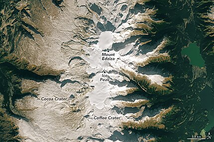 An overhead view of a barren, rocky plateau with a glaciated mountain in the middle.