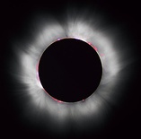 A solar eclipse causes the Sun to be covered, revealing the white corona.