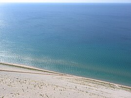 Lake view from the Sleeping Bear Dunes National Lakeshore, with people climbing uphill