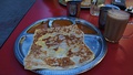 Roti telur with teh tarik, a frothy, milk-infused steeped black tea poured back and forth repeatedly to the ideal serving temperature.