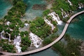 A wooden boardwalk allows passage through a lake, such as this one in Plitvice Lakes National Park, Croatia.