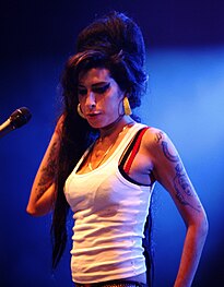 Amy Winehouse with a visible bra strap at a 2007 performance in France