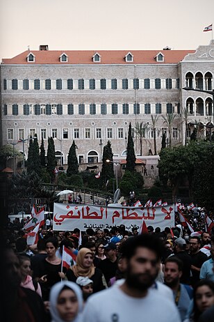 Protesters in front of the Grand Serial, Beirut, carrying a sign that reads "No to Sectarian Rule". 23 October 2019.