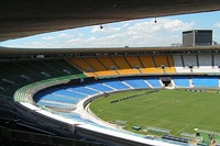 Original configuration of the Maracanã from 1950 to 2010, featuring a two-tier bowl and solid-color seating. (left: Exterior view, 2009. right: interior view looking towards the southern end, 2007.)