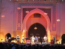 Concert stage with a band performing and the gate of Bab Dekkakin in the background
