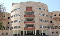 Four-story, round, light-coloured building