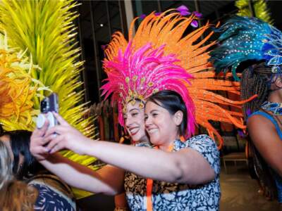 A dancer from SambaViva taking a photo with an attendee at last year’s Latinx Heritage Night. (Courtesy Tim Correira Photography/ SambaViva)