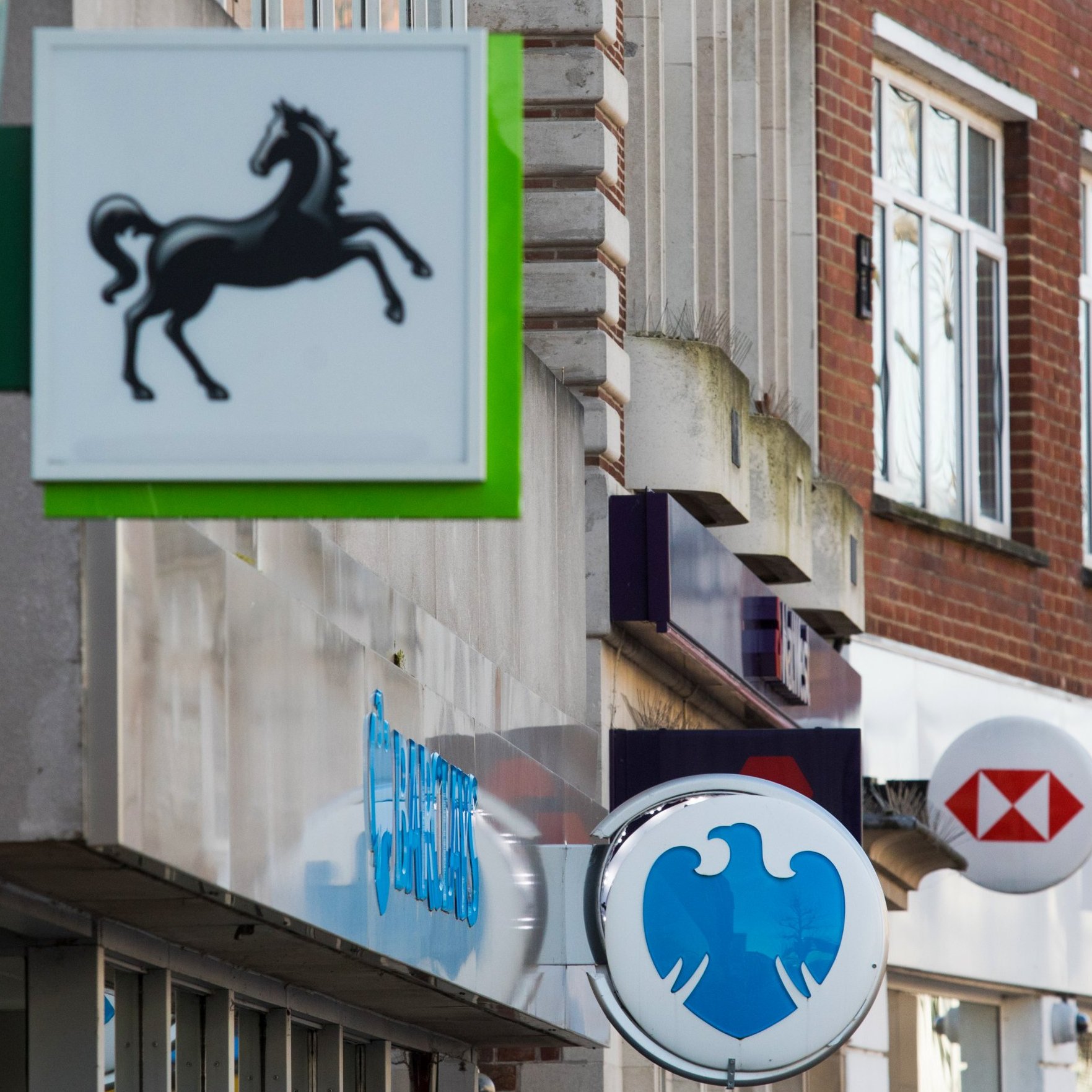 Article thumbnail: Signs outside branches of a Lloyds Banking Group Plc bank, a Barclays Bank Plc bank, a NatWest Group Plc bank and a HSBC Holdings Plc bank in Staines, U.K., on Friday, Feb. 12, 2021. The U.K. economy grew at double the pace expected in the fourth quarter, showing signs of resilience to coronavirus restrictions at the end of a year that delivered the worst recession since 1709. Photographer: Chris Ratcliffe/Bloomberg via Getty Images