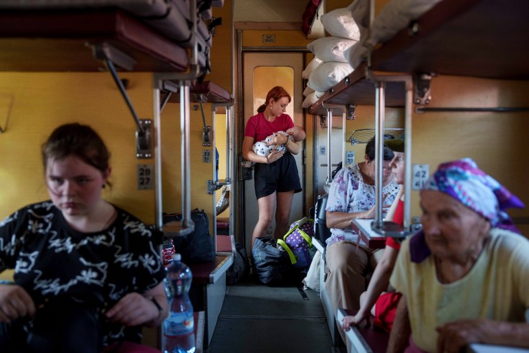 A girl calms her sister on an evacuation train in Pokrovsk, Donetsk region, Ukraine