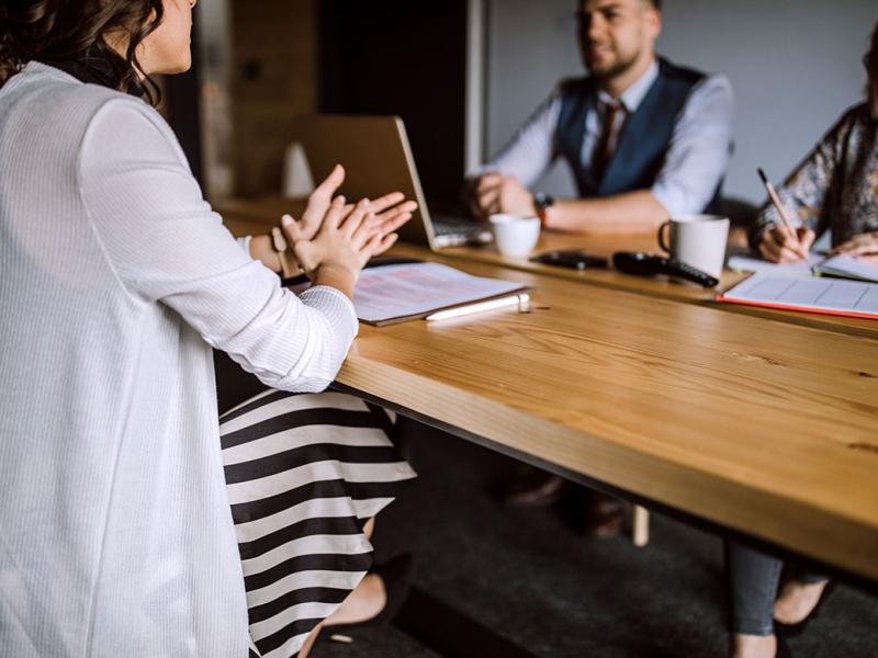 Three people sitting at a desk in a business environment