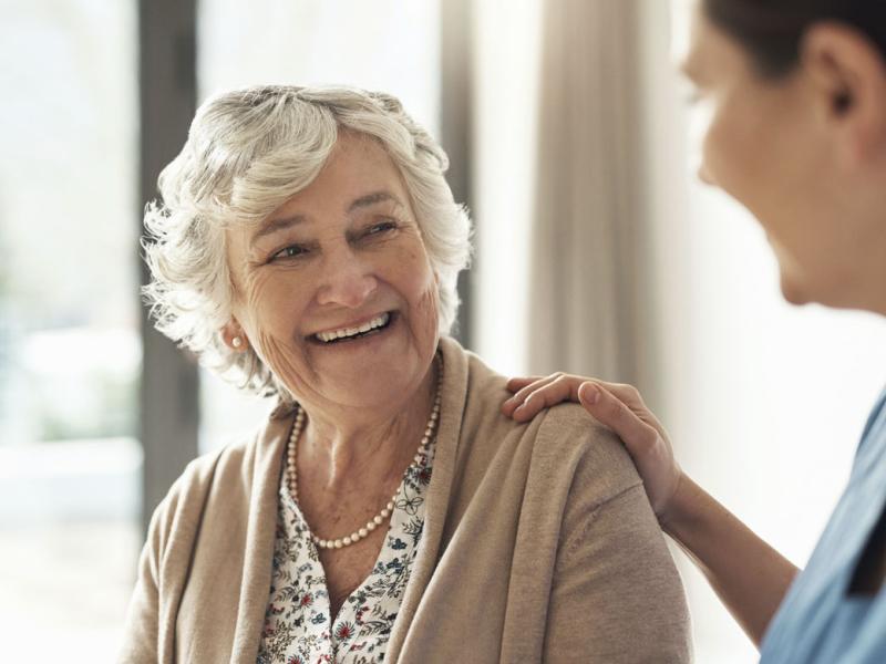Smiling senior patient with health care worker