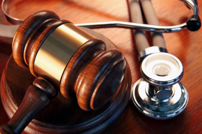 Close-up of gavel and scope resting on a desk.