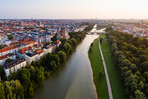 Vue aérienne de Munich montrant une rivière, des arbres et un sentier pédestre longeant la rivière.