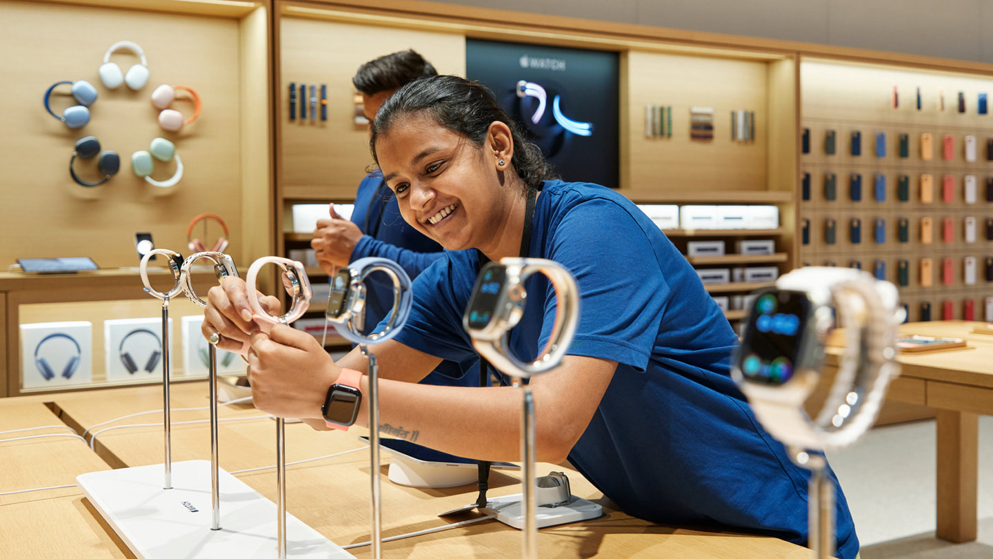 Una persona del equipo ajusta la correa de un Apple Watch Series 9 expuesto en una mesa de Apple BKC, Mumbai.