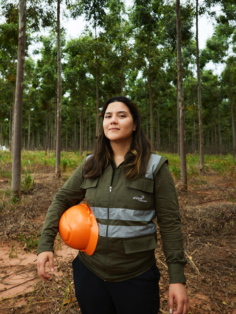 Belén Osario sostiene un casco en el bosque.