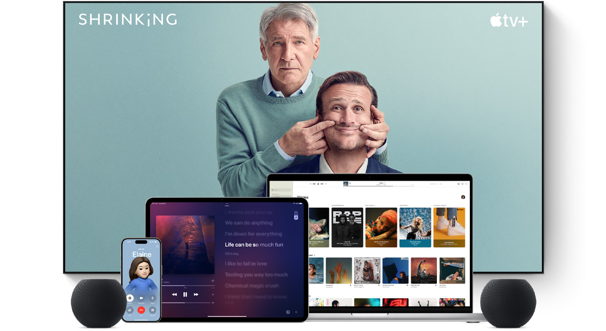 ทีวีจอแบนขนาดใหญ่แสดงตัวละครชายสองคนจากซีรีส์เรื่อง Shrinking ของ Apple TV+ โดยมี MacBook Pro, iPad, iPhone และ HomePod mini สีมิดไนท์วางอยู่ด้านหน้า