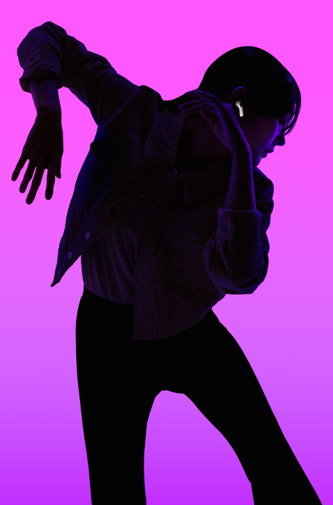 Hình ảnh một người đang nhảy múa, tay trái úp, hướng xuống dưới, tay phải úp, hướng lên trên, gương mặt nổi bật trong ánh sáng nền màu tím, AirPods được đeo vừa vặn bên tai phải .