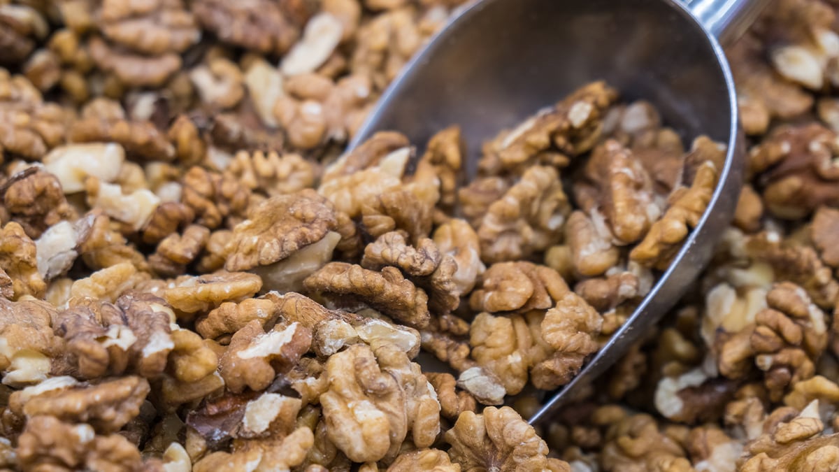 Bulk organic walnuts being scooped up