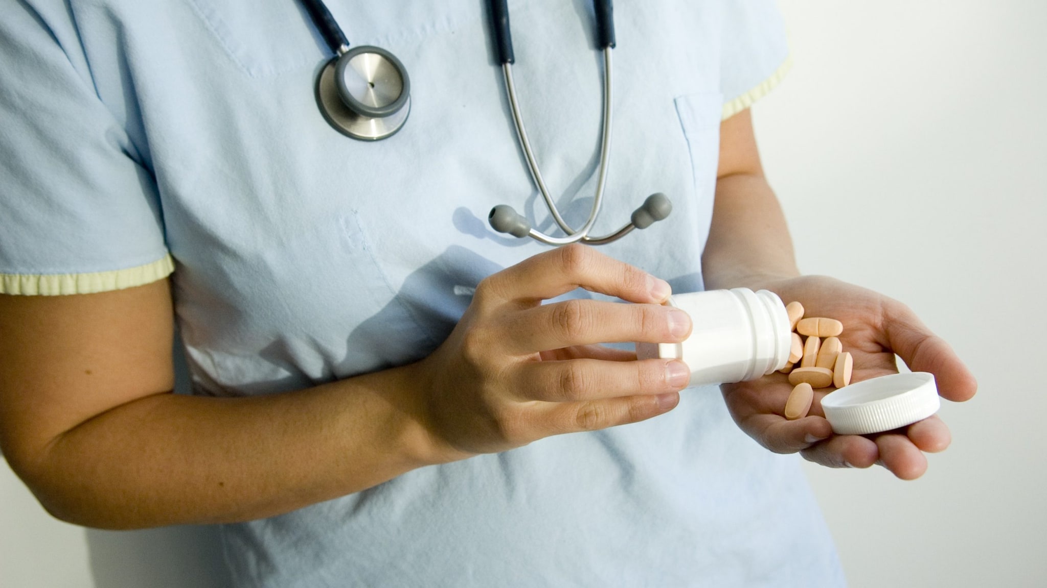 Doctor handing a patient a bottle of pills