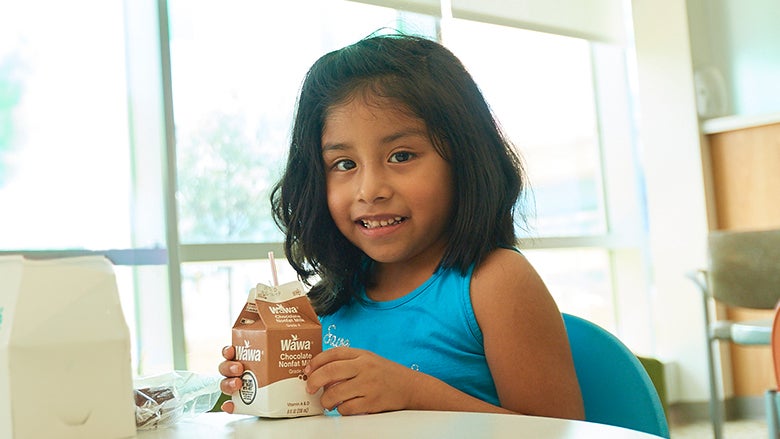 School age girl at lunch table