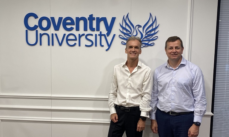 Two men standing next to a Coventry University sign at the new China Hub