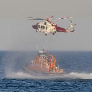 RNLI Funday and Lifeboat display at Nothe Gardens, Weymouth.  The coastguard helicopter makes an unscheduled appearance to lift a winch man off the RNLI lifeboat, after it was involved in a emergency on Portland.  29th July 2024.  Picture Credit: Graham