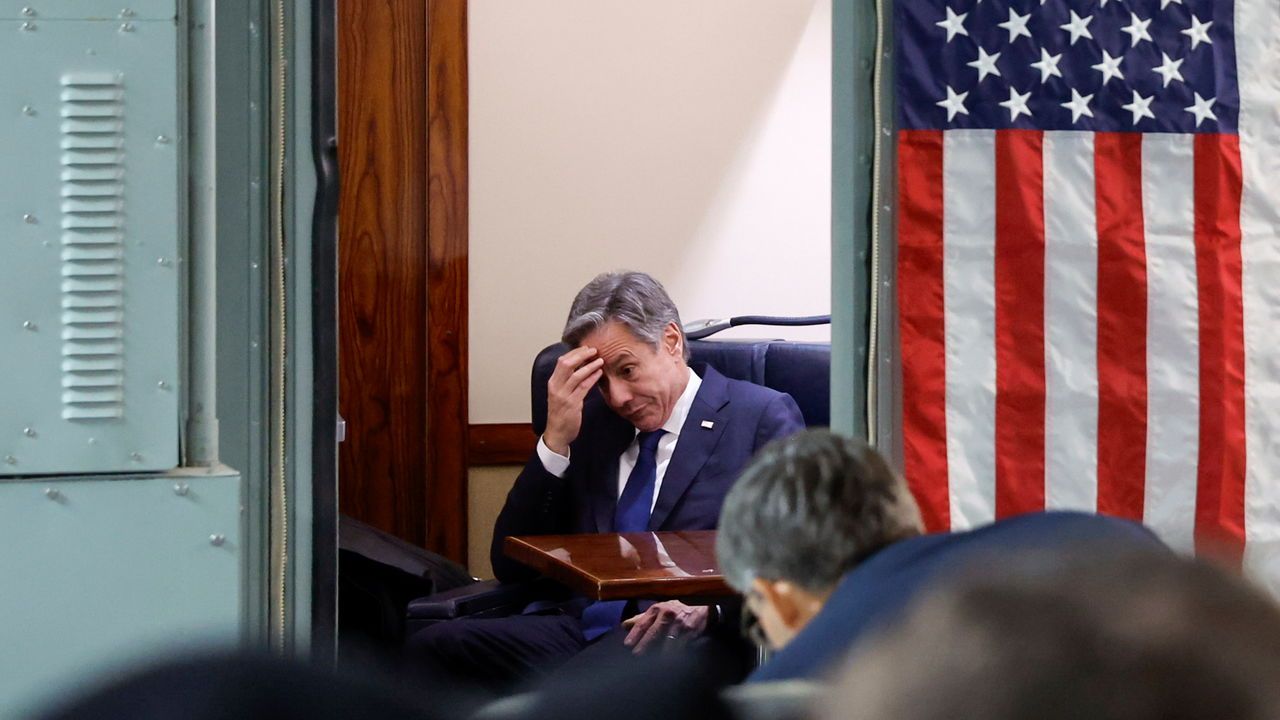 U.S. Secretary of State Antony Blinken sits with his head in his hands onboard the plane during his visit to Israel as he departs en route to Jordan.