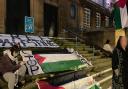 Palestinian flags draped across the steps of City Hall by protestors