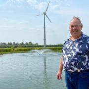 Brian Rivett, a Norfolk farmer, next to the pond he has created in his garden