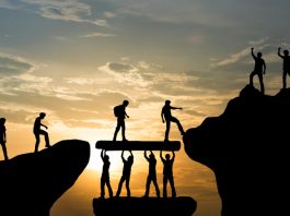 Group of people climbing and helping each other