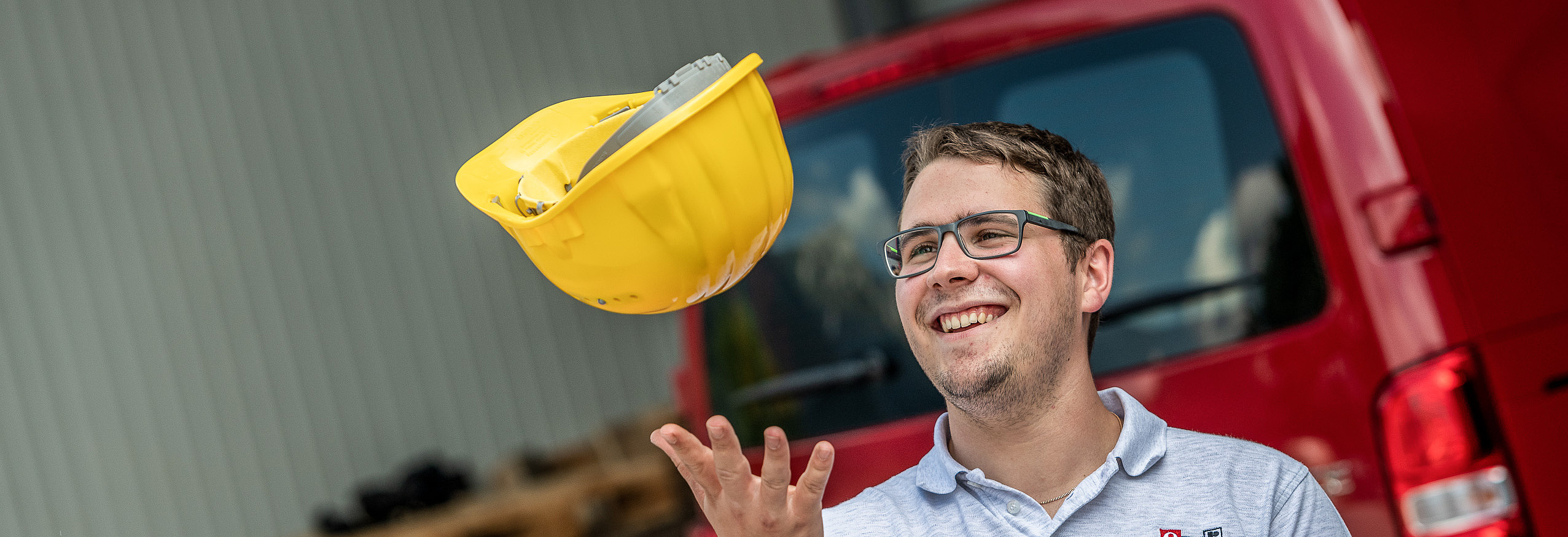 Arbeiter wirft fröhlich seinen Helm in die Luft