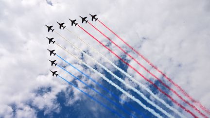 L'équipe de vol acrobatique d'élite de l'armée de l'air française "Patrouille de France" (PAF) effectue un survol lors du défilé militaire de la Fête nationale sur l'avenue des Champs-Elysées à Paris le 14 juillet 2023. (EMMANUEL DUNAND / AFP)