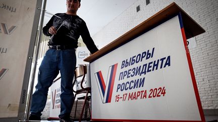 Un bénévole prépare un bureau de vote avant l'élection présidentielle, à Moscou le 14 mars 2024. (ALEXANDER NEMENOV / AFP)