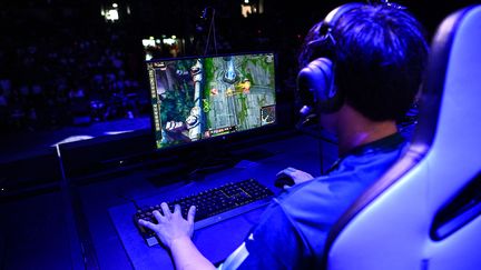 Un esportif professionnel joue à "League of Legends" lors d'une compétition sur scène. (Illustration) (CHRISTOPHE ARCHAMBAULT / AFP)