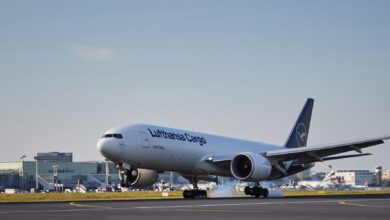 A Lufthansa Cargo jet touches down on a runway.