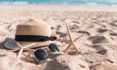 Sonnenhut, Sonnenbrille und Seesterne im Strand (Foto: Freepik) Booking Aktie: Der Reisegigant überzeugt - das perfekte Sommer-Investment