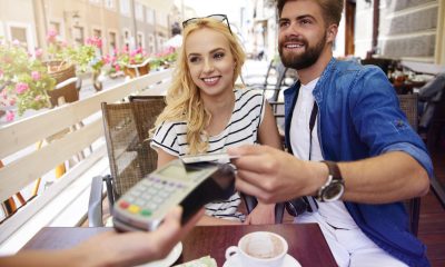 Paar bezahlt in einem Restaurant mit Bankkarte (Foto: Freepik, gpointstudio) Bezahlen im Ausland: per Handy, Apple Pay oder bar – darauf sollten Urlauber achten