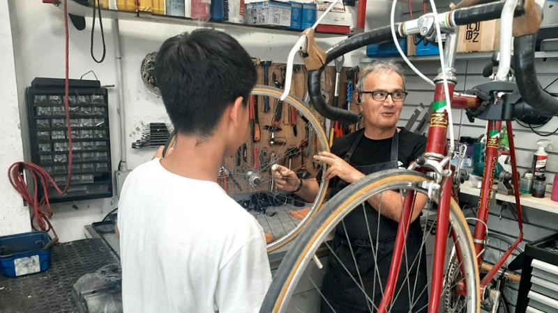 Il titolare Davide Mazzarrisi con uno dei ragazzi a cui ogni settimana fa da tutor per i lavori di officina
