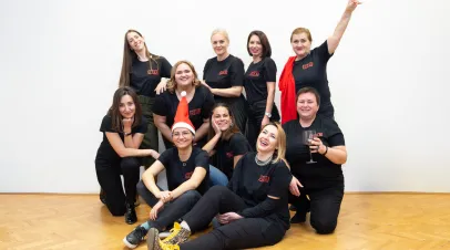 Group of people standing in front of a wall and smiling