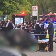 Police at Stamford Hill while paramedics treat a woman