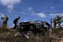 Palestinians gather around the car destroyed car (Majdi Mohammed)