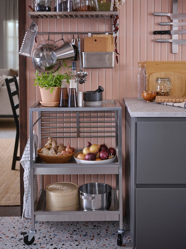 Various kitchenware on a kitchen cart and a suspension rail with a shelf and rail in the stainless steel KUNGSFORS series.