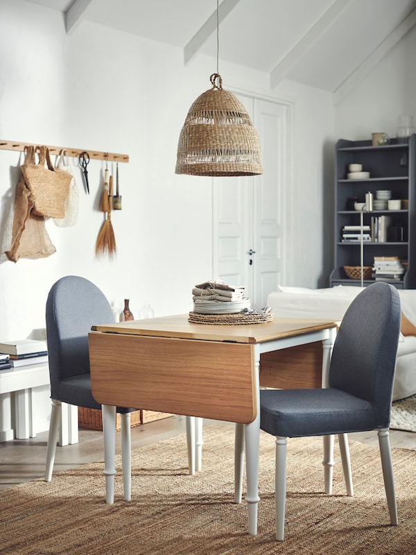 An airy, light room with a DANDERYD drop-leaf table and two grey-and-white DANDERYD chairs beneath a TORARED sedge pendant.