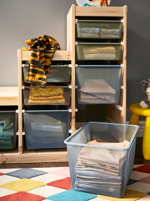 Birch TROFAST storage units with blue and green mesh drawers in it.