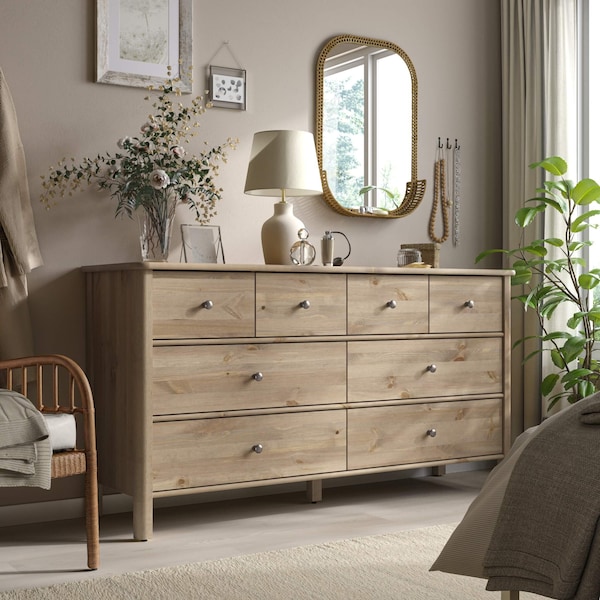 A dresser with vases and plants on top of it.