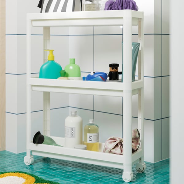 White rolling bathroom organizer with care products on it.