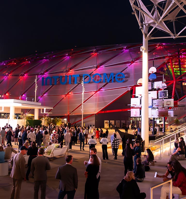 A large crowd of people walking around a large building.