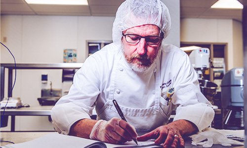 A researcher writing down findings at K-State's Olathe, Kansas campus